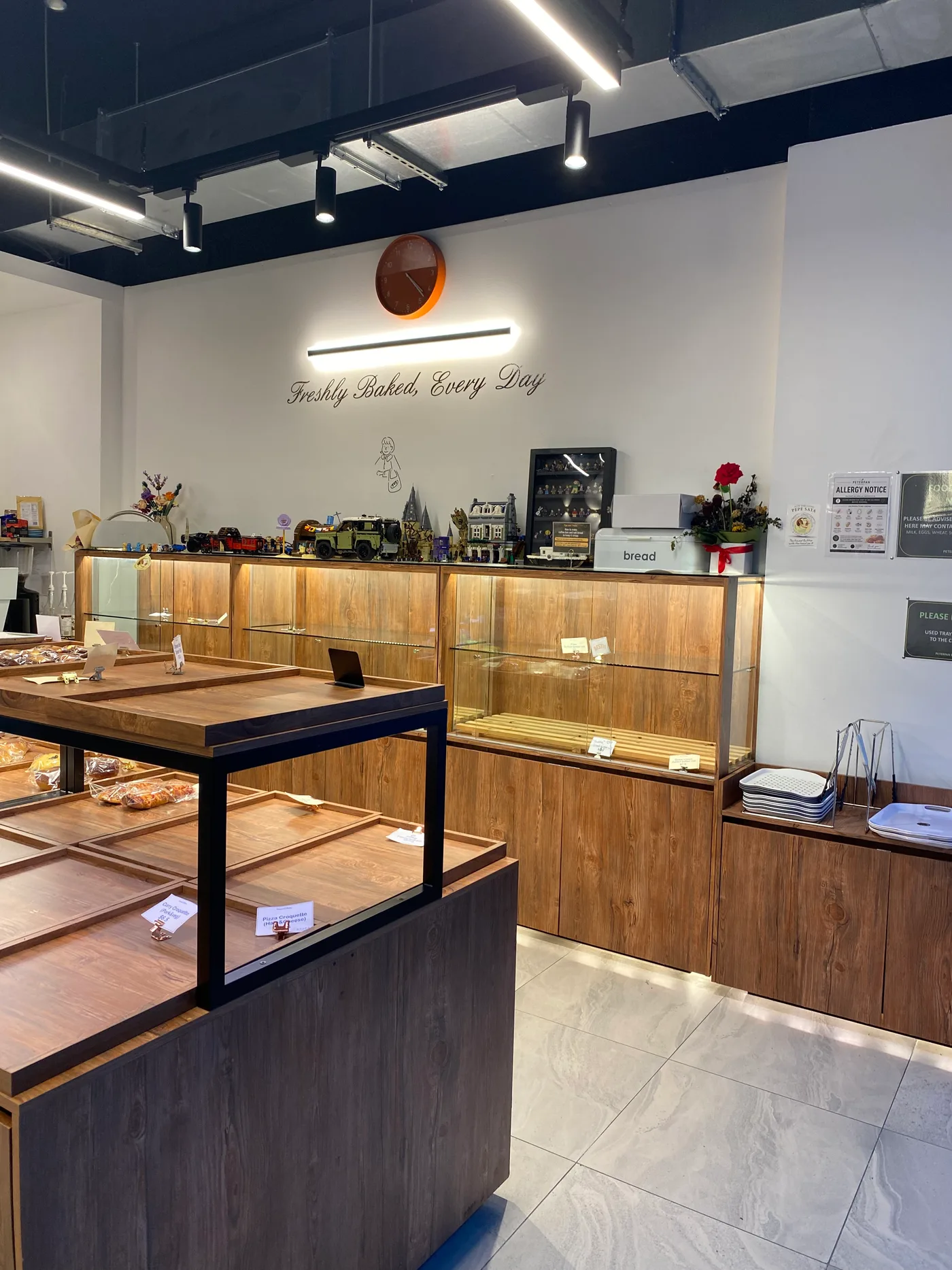 Inside Peterpan Bakery in Southport: timber display cases under the &ldquo;Freshly Baked, Every Day&rdquo; wall script